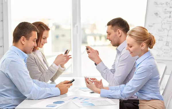 Бизнес-команда с помощью смартфонов в офисе — стоковое фото