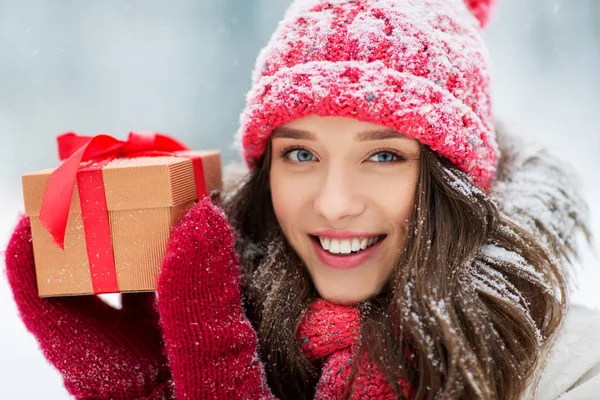 Gelukkige jonge vrouw met kerstcadeau in de winter — Stockfoto