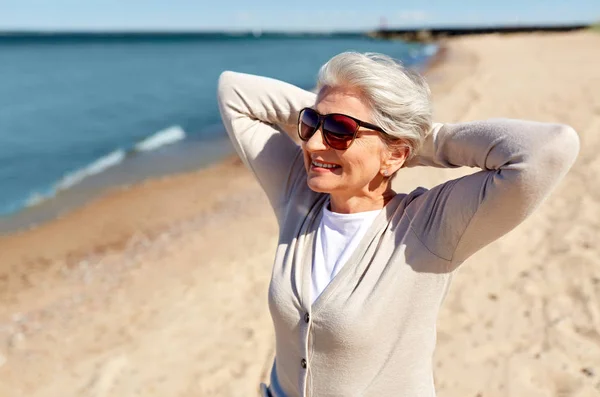 Retrato de mujer mayor en gafas de sol en la playa —  Fotos de Stock