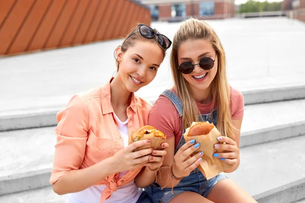 Genç kızlar veya arkadaşlar açık havada hamburger yeme — Stok fotoğraf