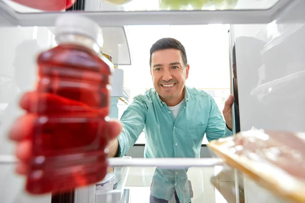 Homme prenant du jus de réfrigérateur à la maison cuisine — Photo