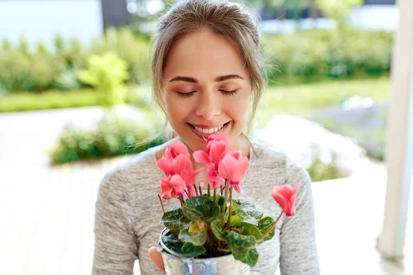 Yaz bahçesinde Siklamen çiçekler ile genç kadın — Stok fotoğraf