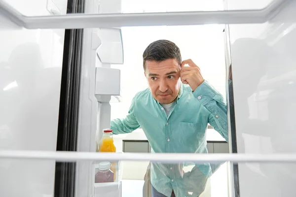 Homem procurando comida na geladeira vazia na cozinha Fotos De Bancos De Imagens Sem Royalties
