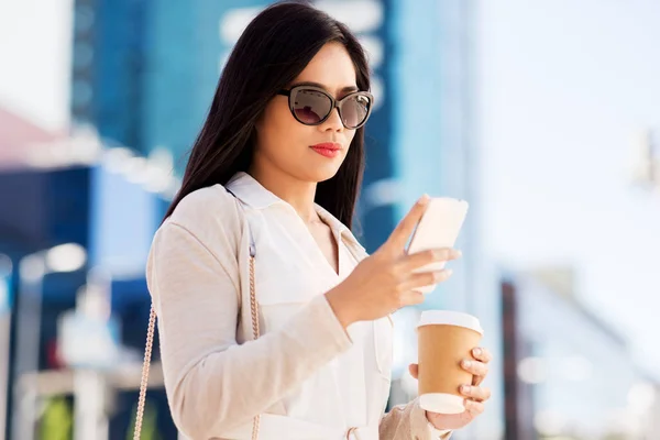 Woman with smartphone and coffee in city — Stock Photo, Image