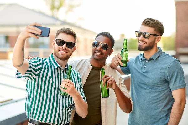 Muži pijí pivo a berou selfie po smartphonu — Stock fotografie