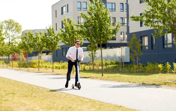 Молодий бізнесмен їде на електричному скутері на відкритому повітрі — стокове фото