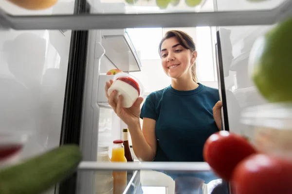 Lycklig kvinna som tar mat från kylskåp hemma — Stockfoto