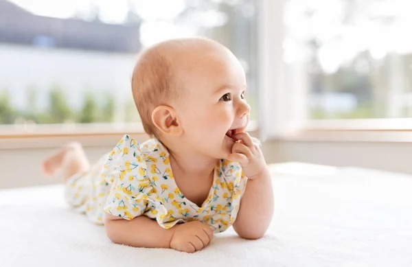 Sweet baby girl lying on white blanket — стоковое фото