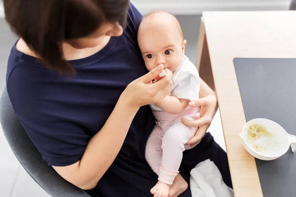 Middle-aged mother feeding baby daughter at home — Stock Photo, Image