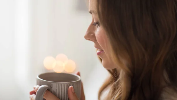 Close-up van gelukkige vrouw met kopje koffie thuis — Stockfoto