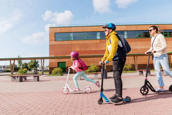Niños de la escuela feliz con la madre que monta scooters —  Fotos de Stock