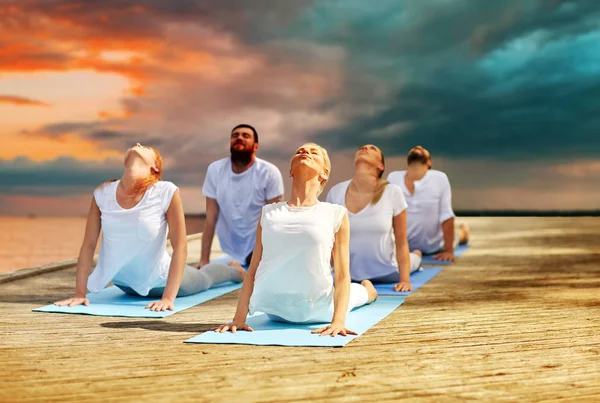 Gruppe von Menschen, die Yoga-Übungen im Freien machen — Stockfoto