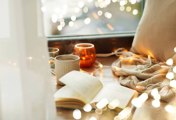 Book and coffee or hot chocolate on window sill — Stock Photo, Image