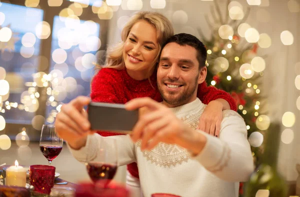 Szczęśliwy para biorąc selfie na Boże Narodzenie obiad — Zdjęcie stockowe
