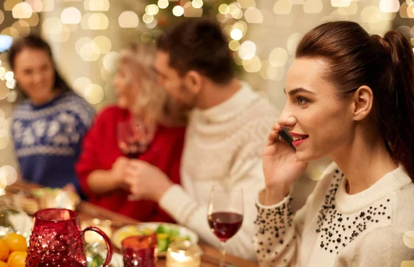 Женщина звонит на смартфон на рождественский ужин — стоковое фото