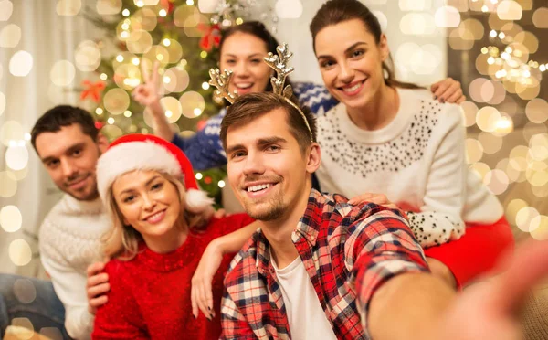 Přátelé slaví Vánoce a brát selfie — Stock fotografie