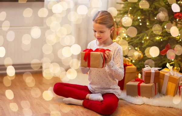 Chica sonriente con regalo de Navidad en casa — Foto de Stock