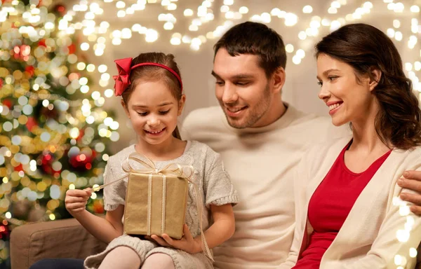 Szczęśliwa rodzina z prezentem świątecznym w domu — Zdjęcie stockowe