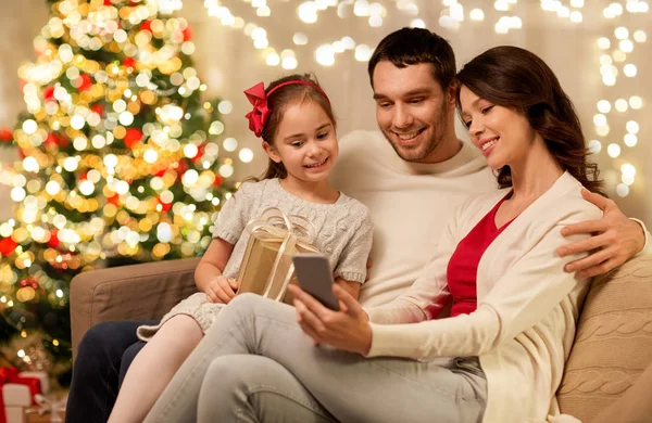 Familie zu Weihnachten mit Smartphone zu Hause — Stockfoto