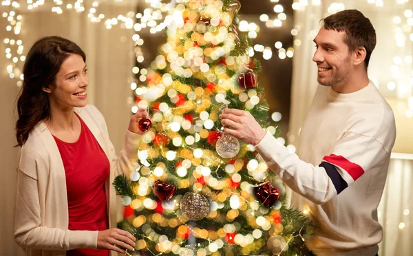 Ευτυχισμένο ζευγάρι διακόσμηση χριστουγεννιάτικο δέντρο στο σπίτι — Φωτογραφία Αρχείου