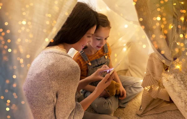 Evde çocuk çadırında akıllı telefonu olan mutlu bir aile. — Stok fotoğraf