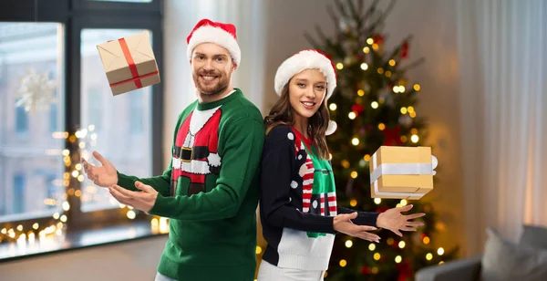 快乐的一对夫妇，头戴毛衣，有圣诞礼物 — 图库照片