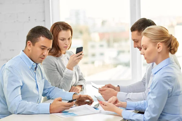 Business team med smartphones på kontoret — Stockfoto