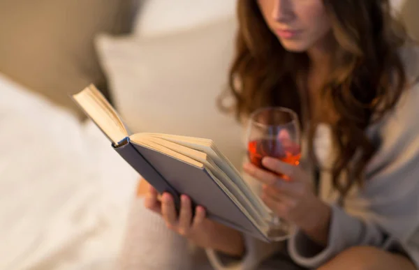 Primer plano de la mujer leyendo libro y bebiendo vino — Foto de Stock