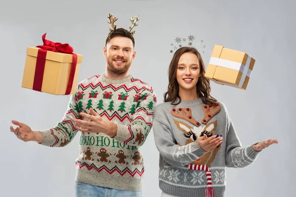 Ευτυχισμένο ζευγάρι σε χριστουγεννιάτικα πουλόβερ με κουτιά δώρων — Φωτογραφία Αρχείου