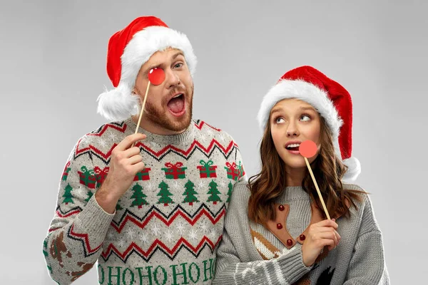 Pareja con accesorios de fiesta de Navidad en suéteres feos —  Fotos de Stock