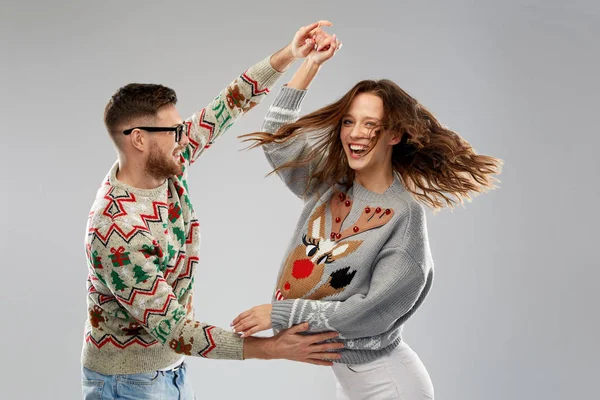Couple dancing at christmas ugly sweaters party — Stock Photo, Image