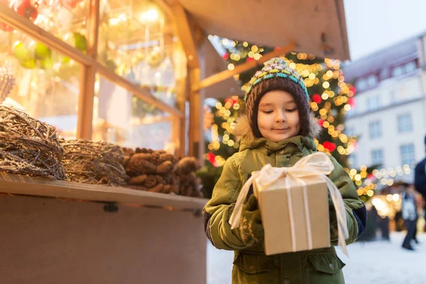 Garçon heureux avec boîte cadeau au marché de Noël — Photo
