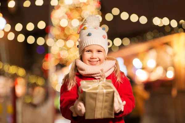 Fille heureuse avec boîte cadeau au marché de Noël — Photo