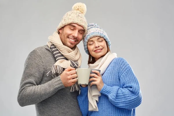 Feliz pareja en ropa de invierno con tazas — Foto de Stock