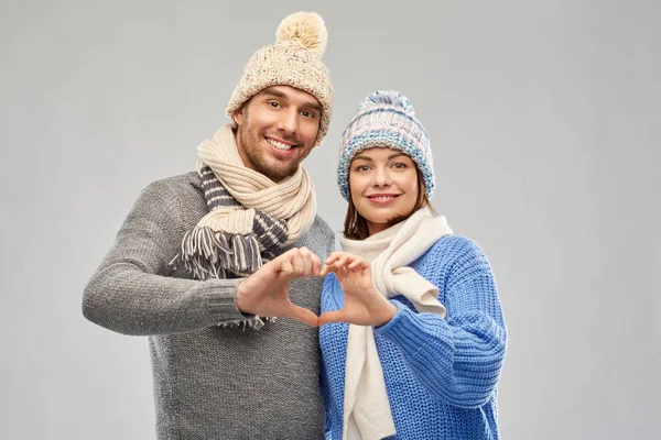 Casal feliz em roupas de inverno fazendo mão coração — Fotografia de Stock