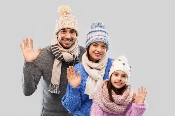 Família feliz em roupas de inverno acenando as mãos — Fotografia de Stock