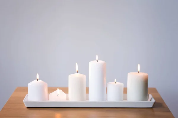 Burning white candles on tray on table — Stock Photo, Image