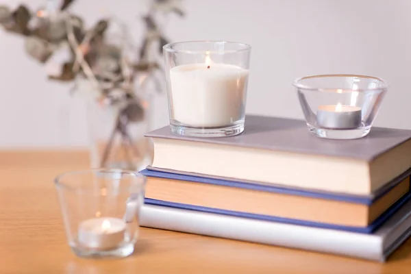 Geurkaarsen branden en boeken op tafel — Stockfoto