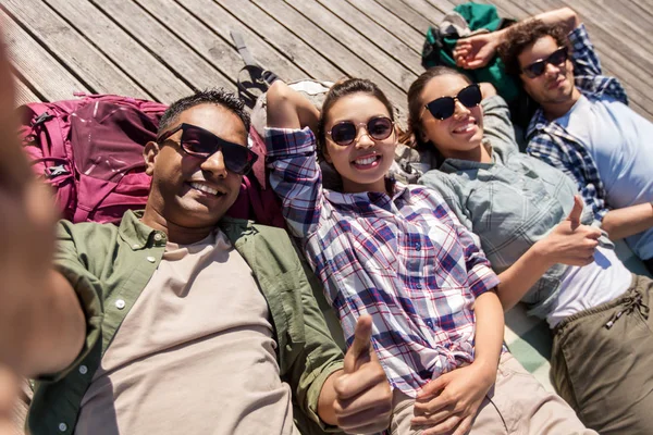 Amigos o turistas con mochilas tomando selfie — Foto de Stock