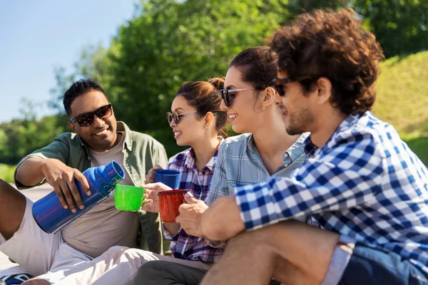 Amici felici bere il tè dal thermos in estate — Foto Stock