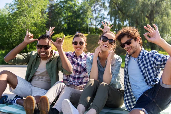 Amigos felizes fazendo rostos no parque de verão — Fotografia de Stock