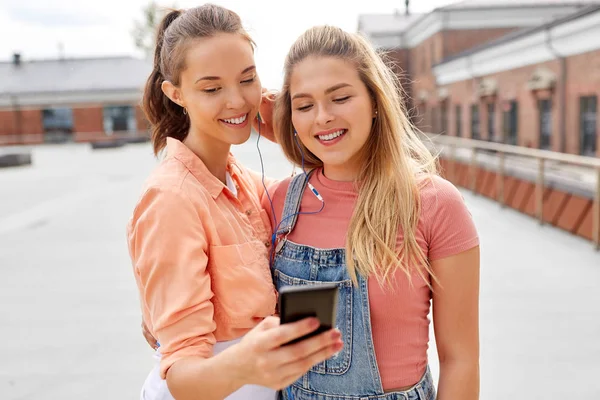 Tizenéves lányok, hallgató-hoz zene-ra smartphone — Stock Fotó