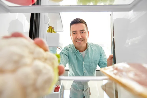 Homme prenant des légumes du réfrigérateur à la maison cuisine — Photo