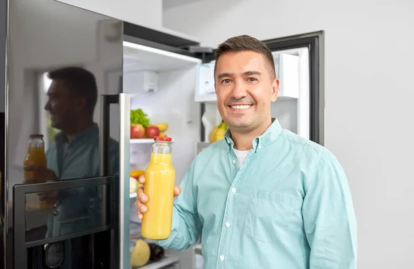 Man tar saft från kylskåp hemma kök — Stockfoto