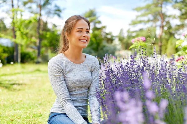 Ung kvinna och lavendel blommor på Summer Garden — Stockfoto