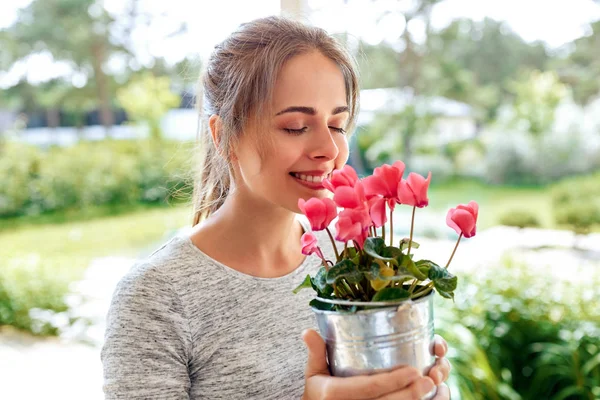 Young woman with cyclamen flowers at summer garden — Stock Photo, Image