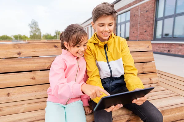 Barn med Tablet PC sitter på bänken — Stockfoto