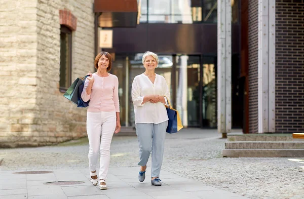 Senior vrouwen met boodschappentassen wandelen in de stad — Stockfoto