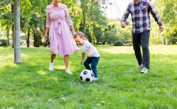 Família feliz jogando futebol no parque de verão — Fotografia de Stock