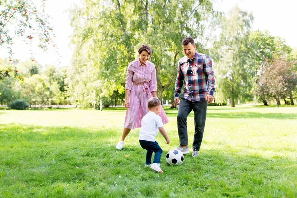 Счастливая семья играет в футбол в летнем парке — стоковое фото